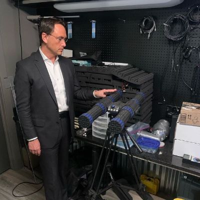 He is wearing a suit while looking at the equipment.